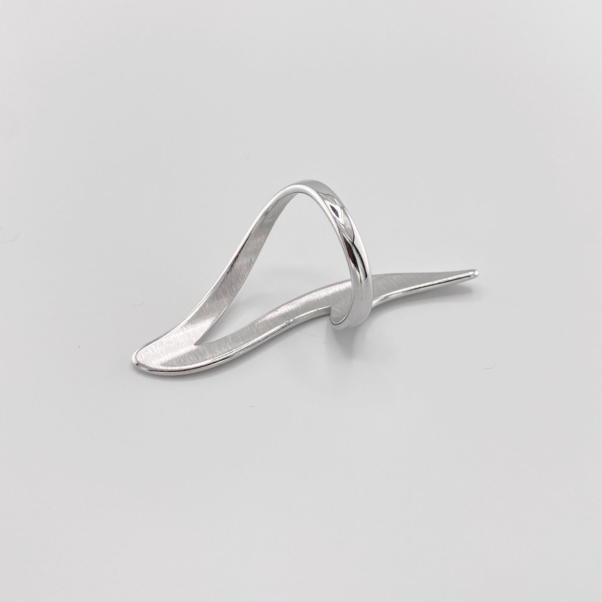Bague argentée en forme de vague fluide avec finition miroir moderne