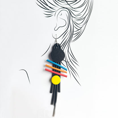 Geometric Sonata earrings worn on an ear outline with bold color accents