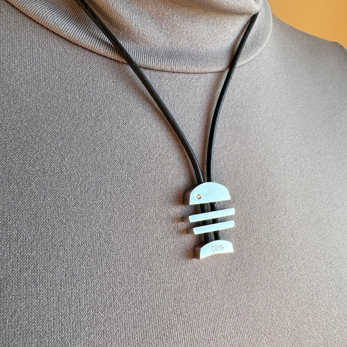 Geometrischer Anhänger an schwarzem Band mit klarer moderner Ästhetik