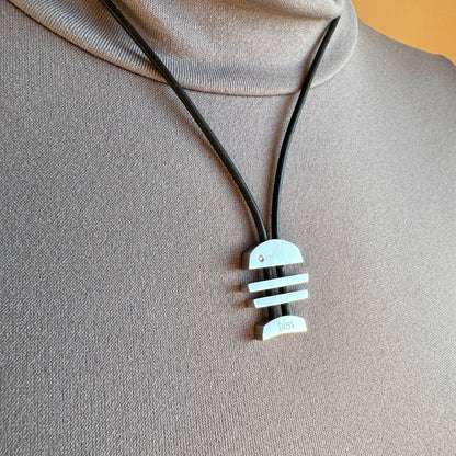 Geometrischer Anhänger an schwarzem Band mit klarer moderner Ästhetik