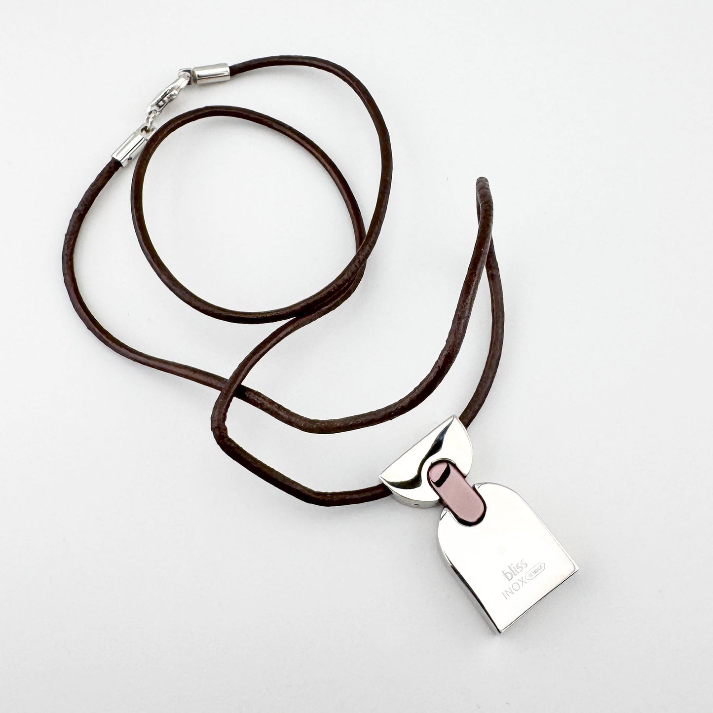 Halskette mit geometrischem Anhänger, braunes Lederband, klarer moderner Stil