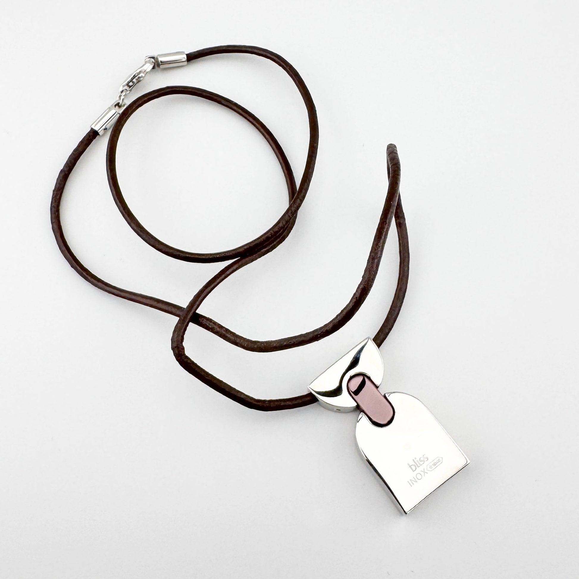 Halskette mit geometrischem Anhänger, braunes Lederband, klarer moderner Stil