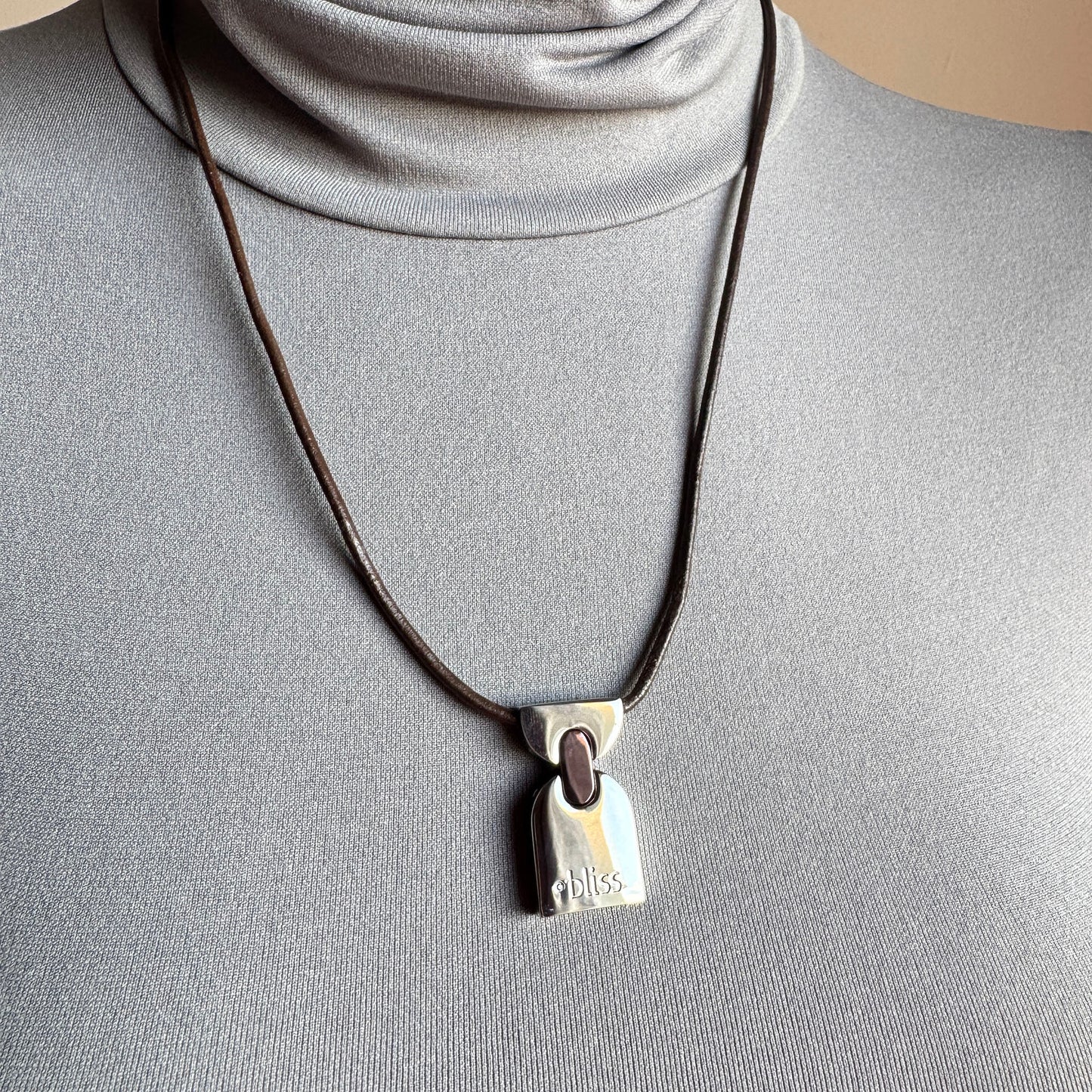Geometric pendant necklace worn on the neck, calm modern statement with leather cord