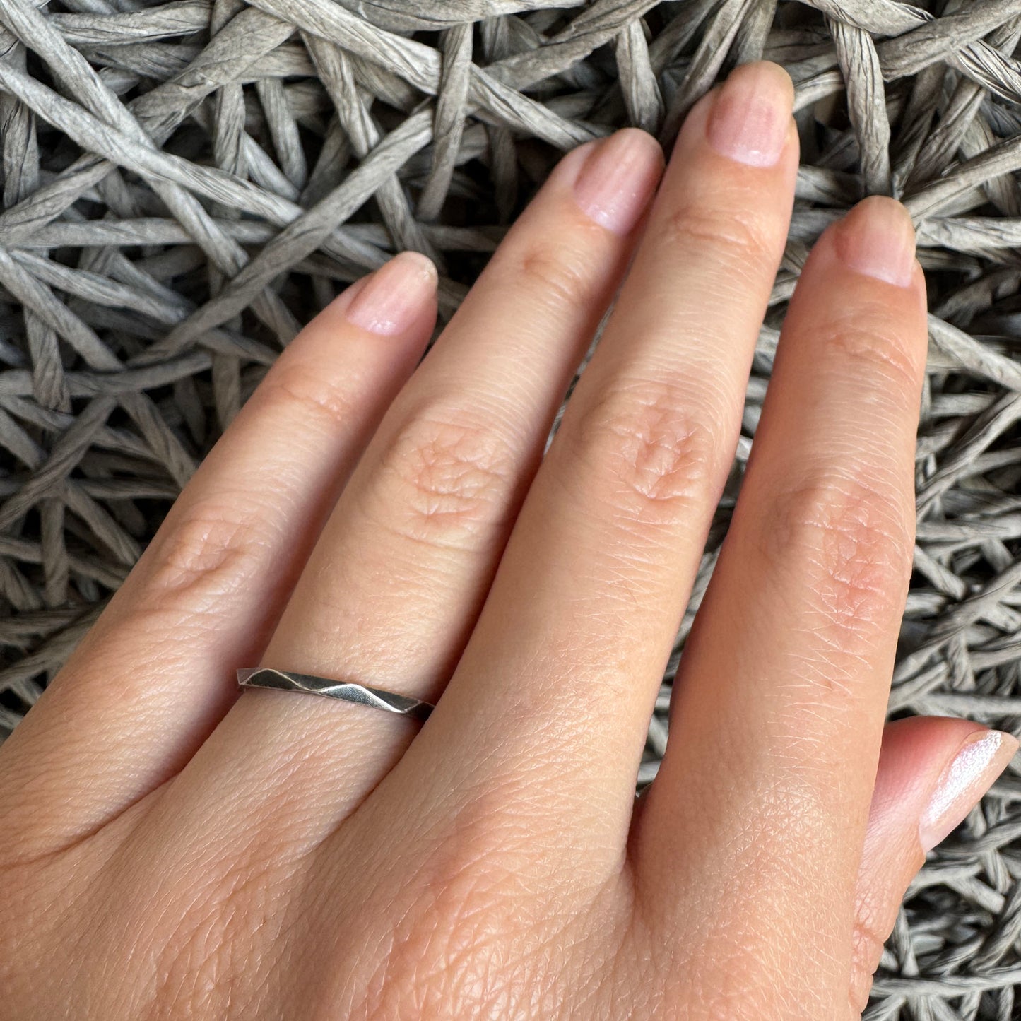 Oxidized 925 silver geometric ring on hand, gentle facets catching light in a clean minimalist style