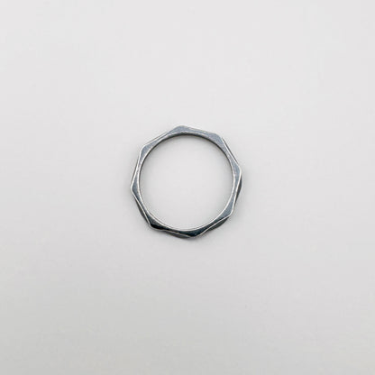 Srebrny pierścionek geometryczny 925 z delikatnymi załamaniami, spokojny minimalizm na jasnym tle
