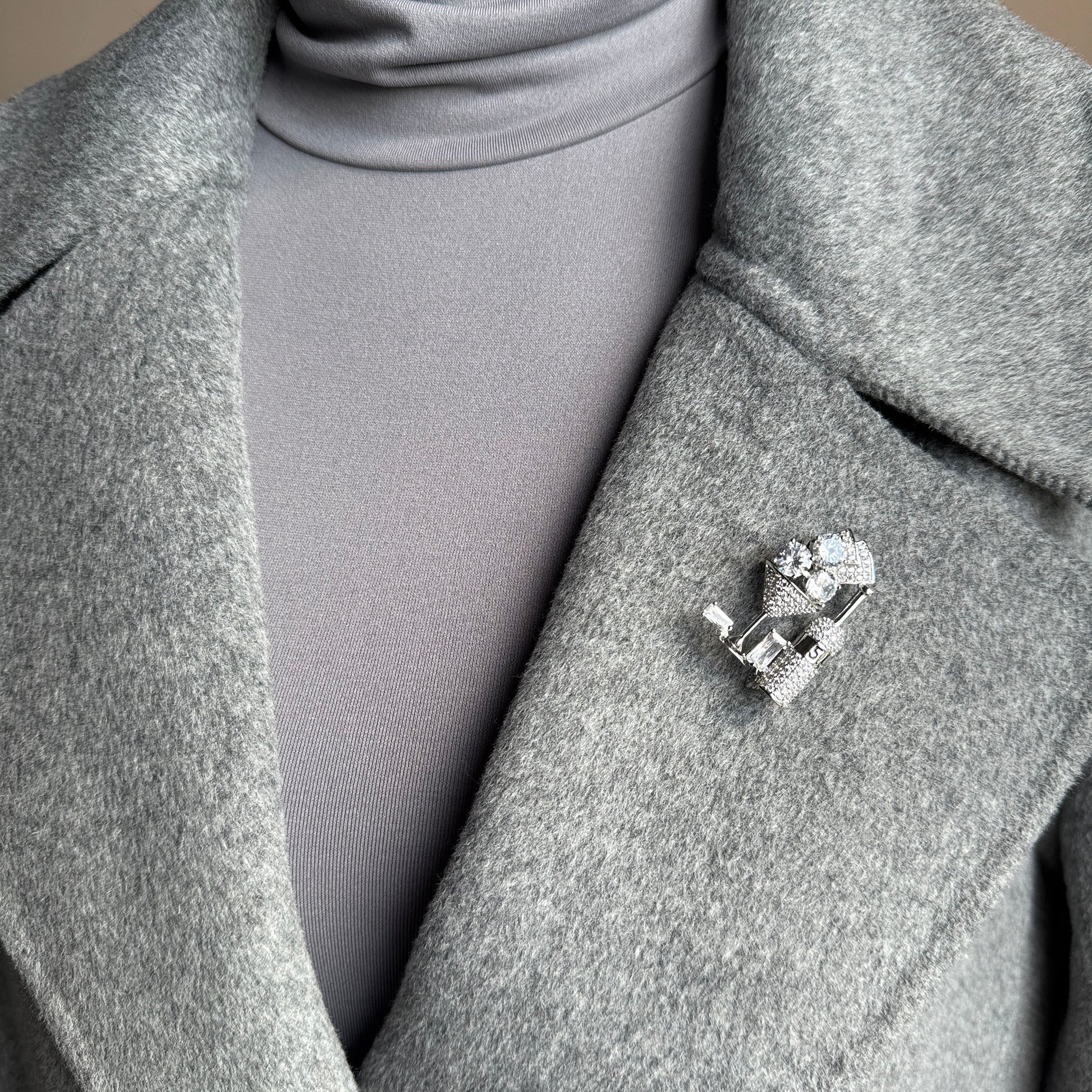 Sparkling cocktail glass brooch worn on coat, ideal for parties and holiday looks