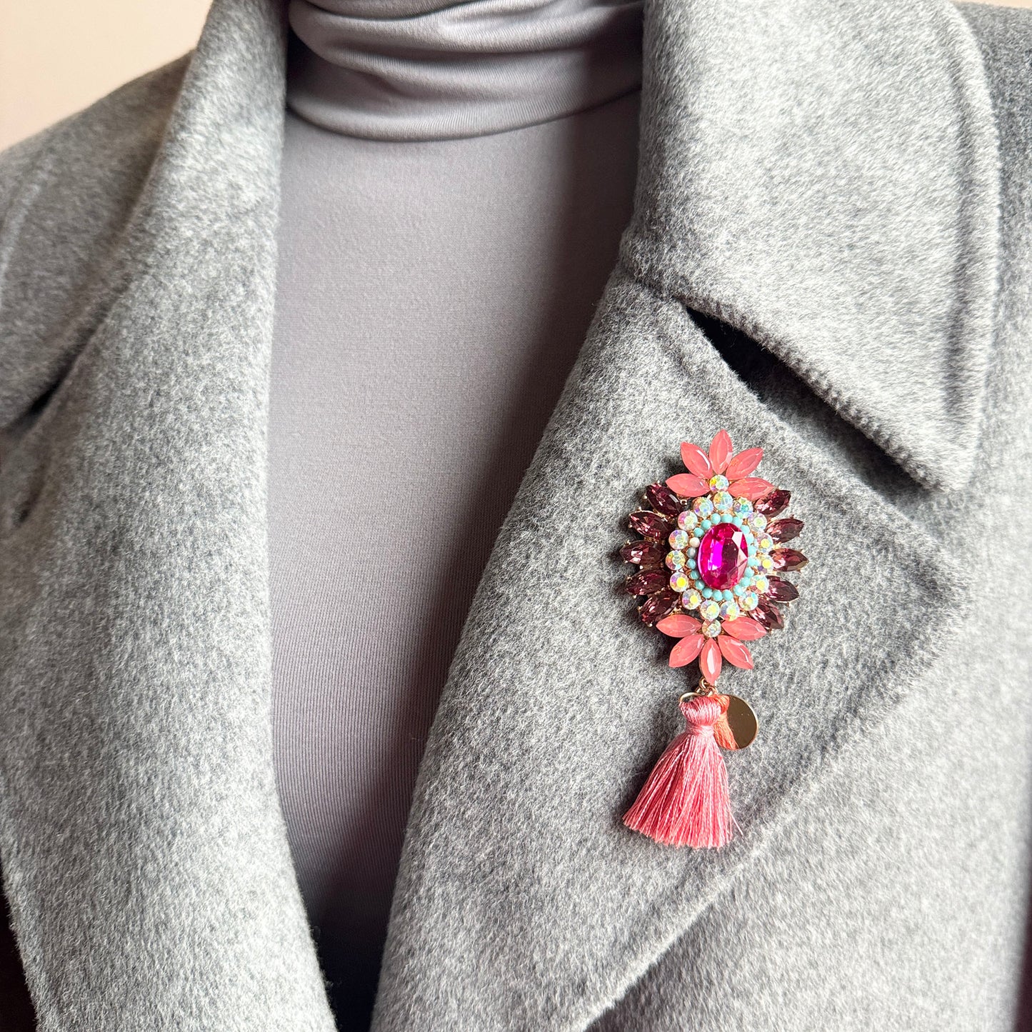 Glamour floral brooch Sonata worn on a coat with a pink tassel