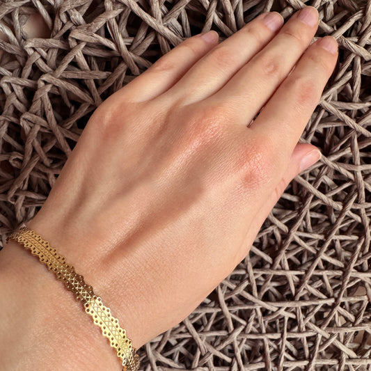 Gold textured cuff bracelet IRL worn on the wrist with an open minimalist shape