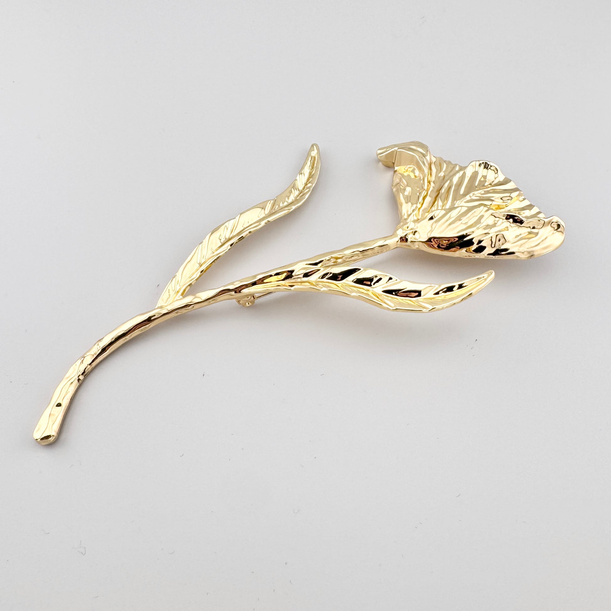 Broche Sonata con forma de tulipán dorado y hojas alargadas decorativas