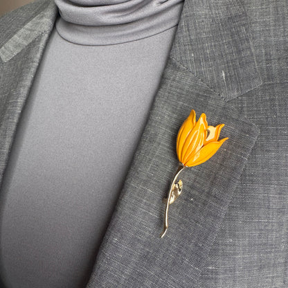 Gold flower brooch Sonata worn on a blazer with a slender curved stem