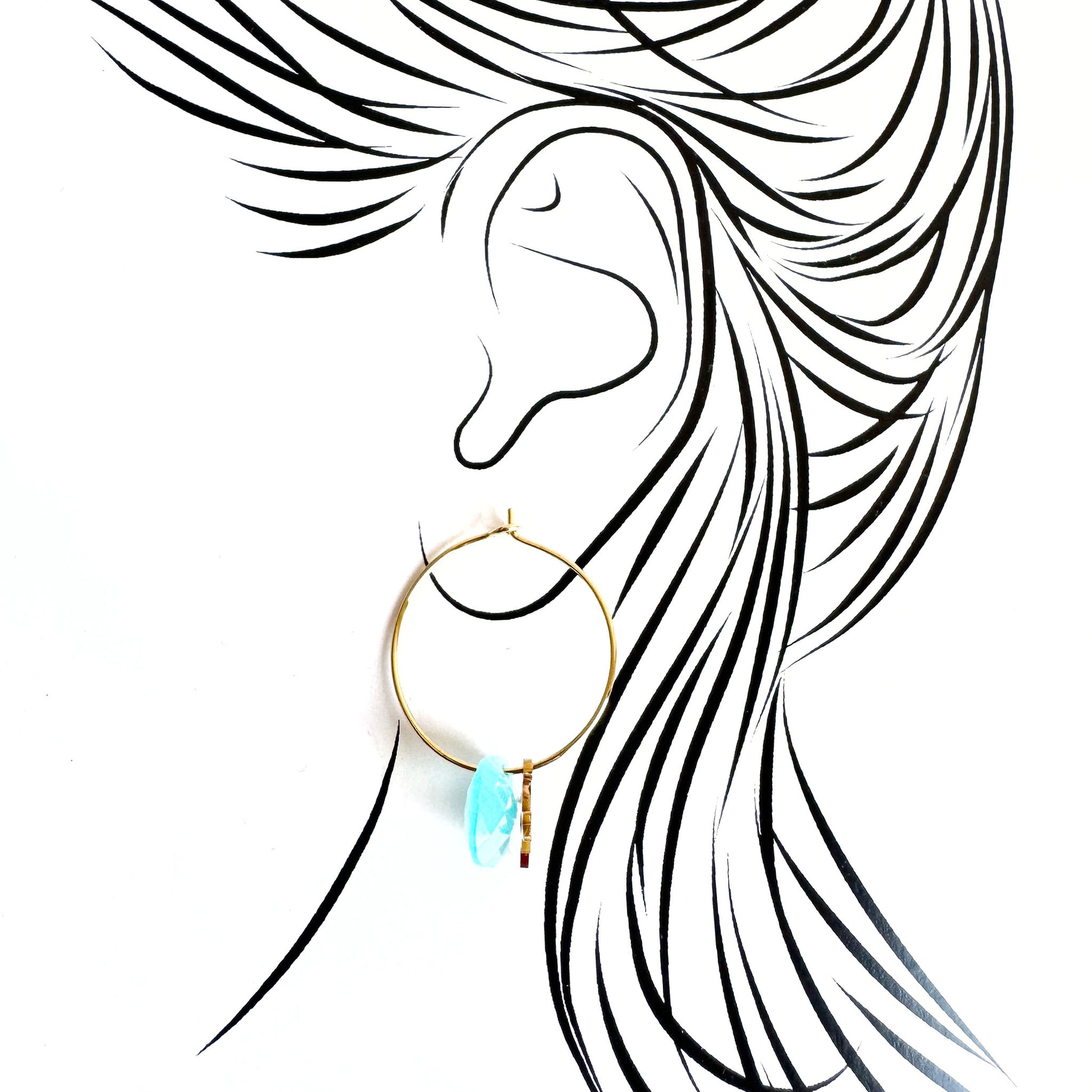 Gold IRL hoop earrings with light blue stone and star charm worn on ear illustration