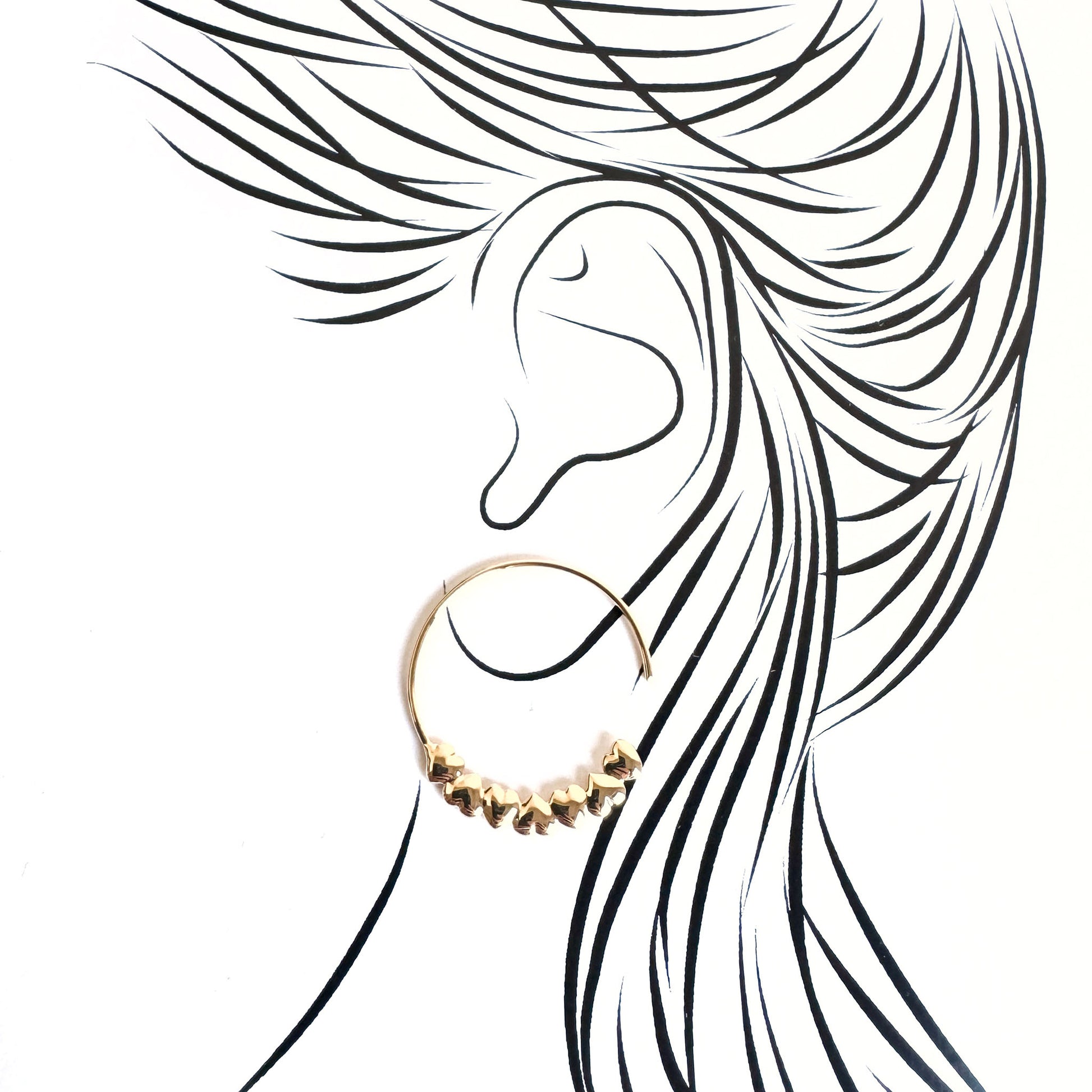 Delicate gold hoop earrings with heart details illustrated on an ear silhouette