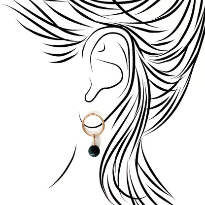 Pilgrim gold hoops with deep green stone drop; mirror polish contrasted by the stone’s matte depth