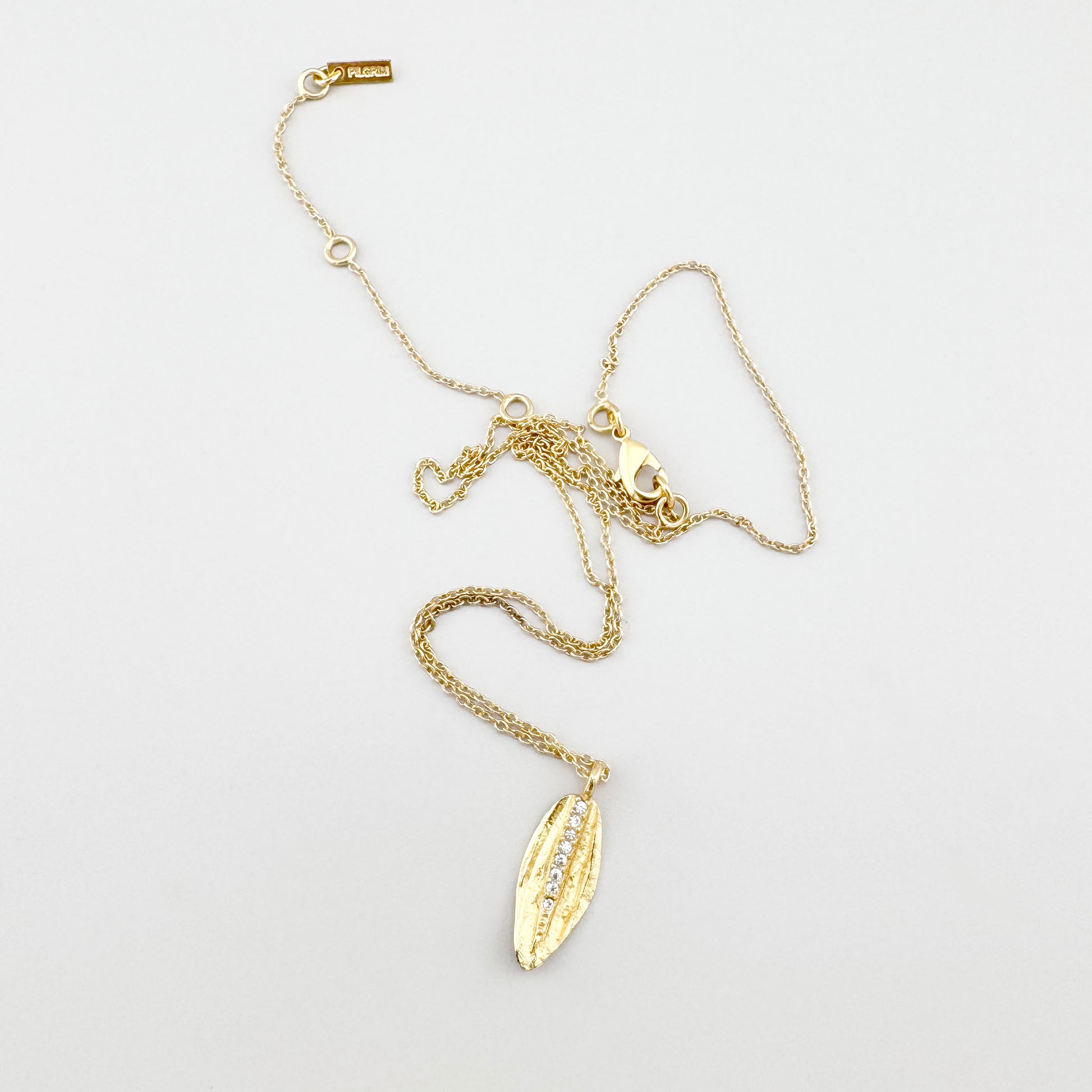 Collier Pilgrim doré avec feuille et zircones présenté sur fond clair