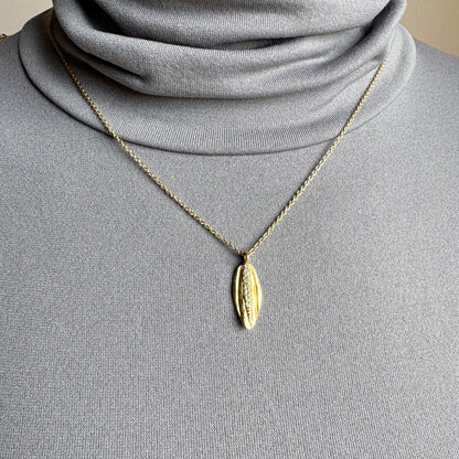 Gold Pilgrim necklace with leaf pendant and zircons worn on neck