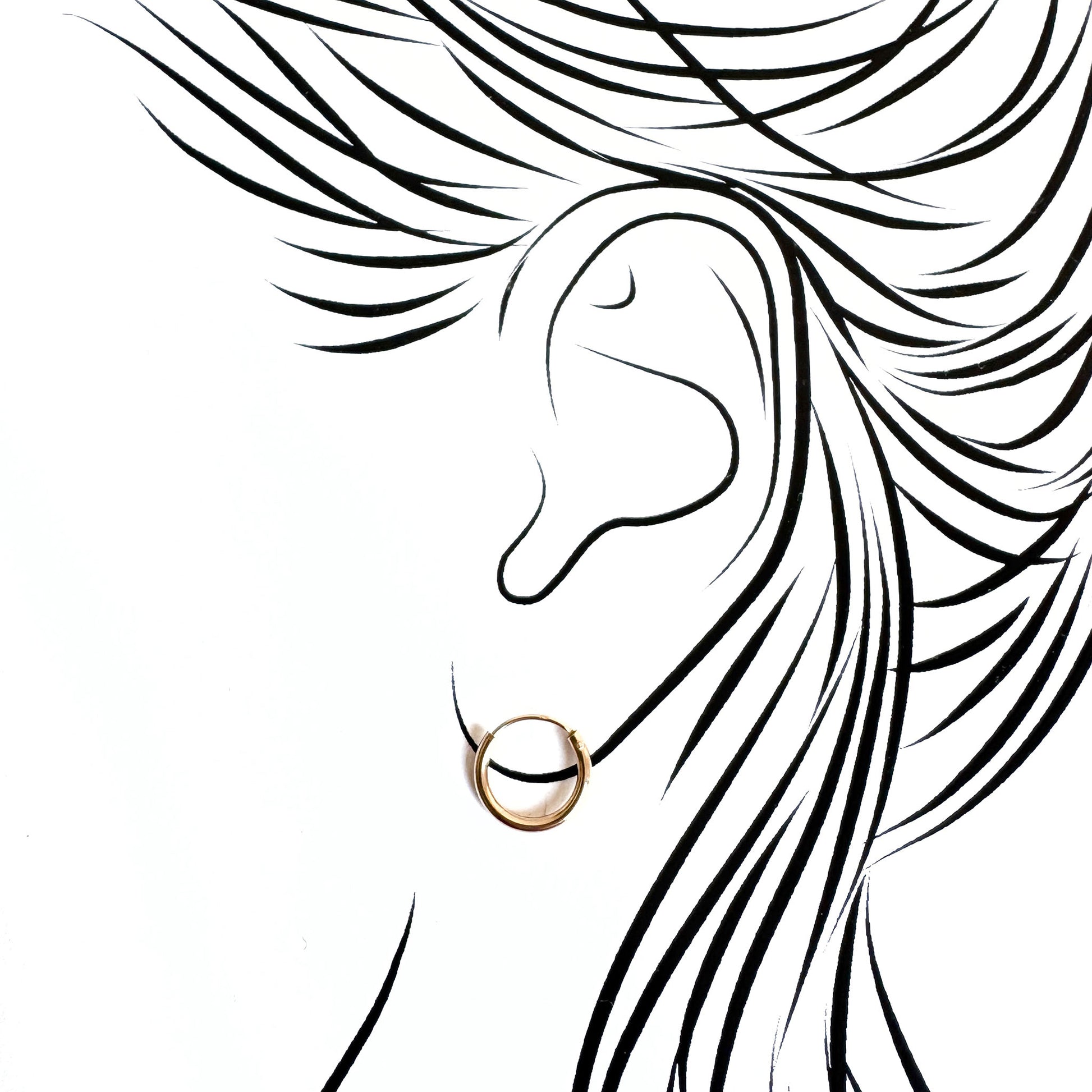 Minimal gold hoops hugging the earlobe with invisible closure