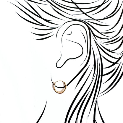 Minimal gold hoops hugging the earlobe with invisible closure