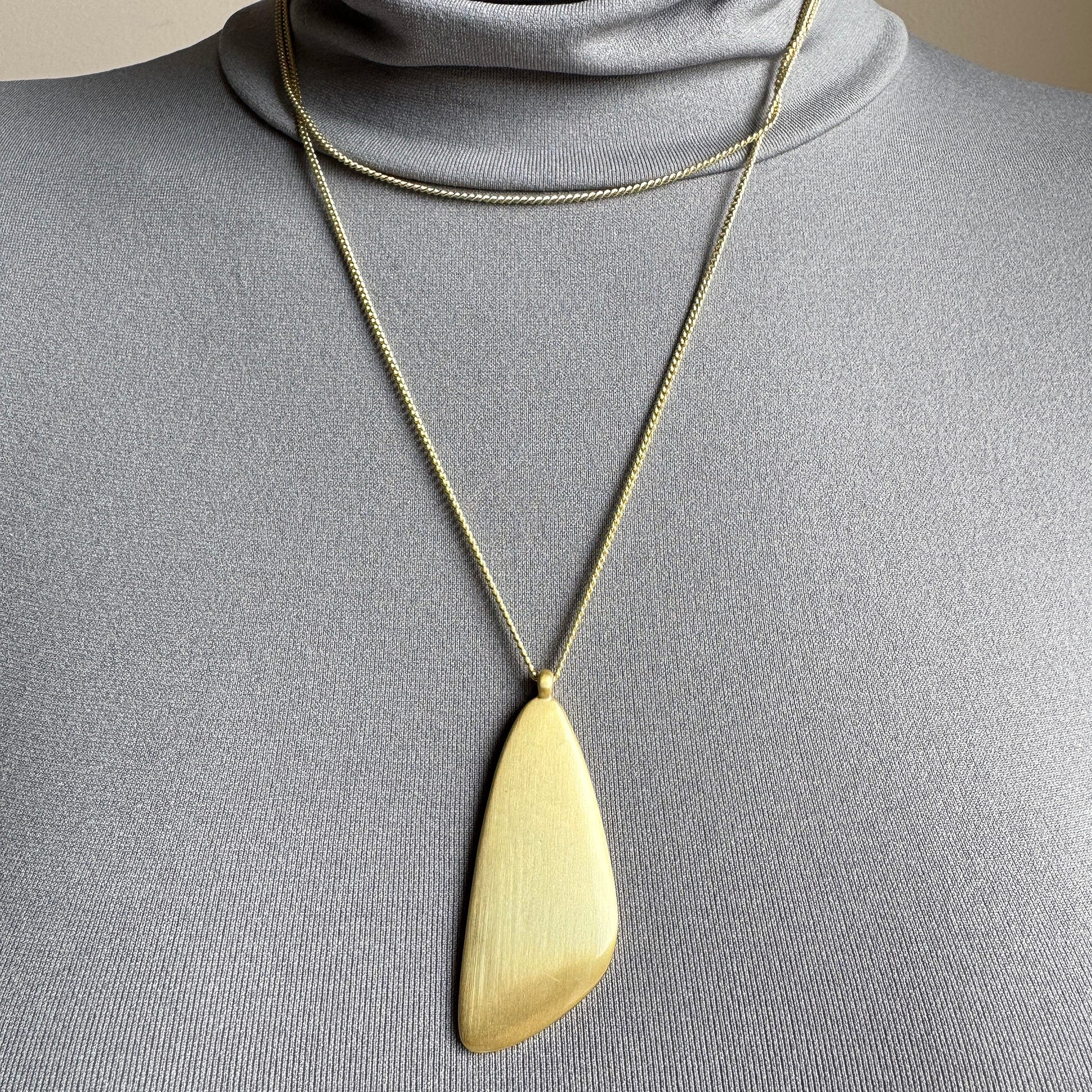Gold Pilgrim necklace with sculptural large pendant worn on neck