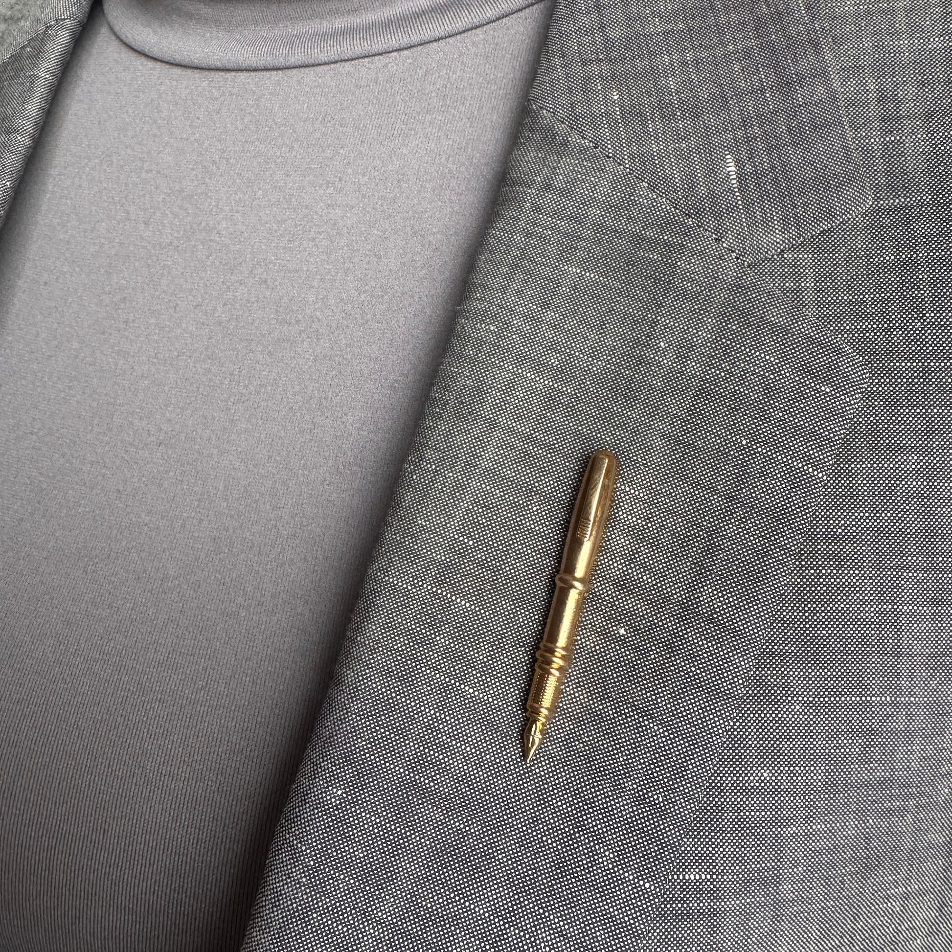 Gold pen brooch Sonata worn on a blazer with a slim polished silhouette