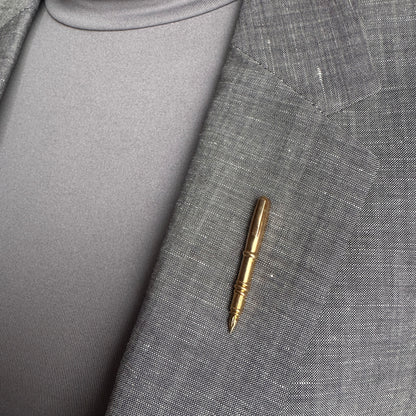 Gold pen brooch Sonata worn on a blazer with a slim polished silhouette