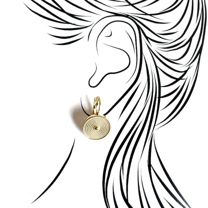 Gold hoop earrings with spiral medallions worn on the ear