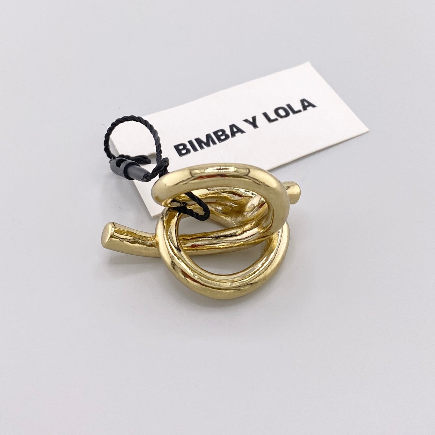Bague nœud sculpturale Bimba y Lola à finition dorée vue du dessus avec son étiquette