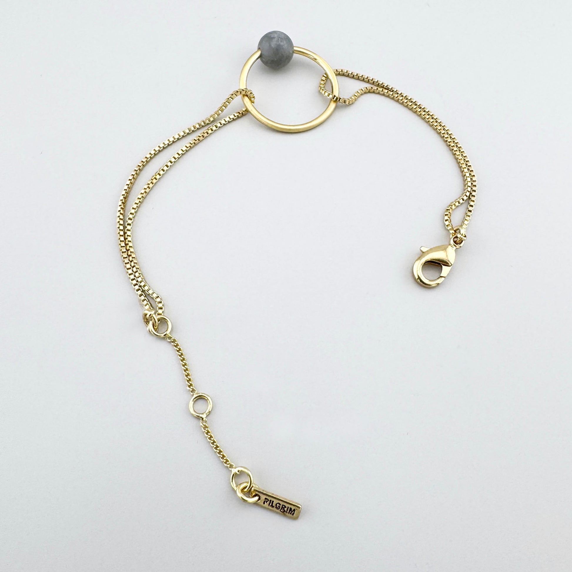 Pulsera con piedra gris y brillo dorado, detalle minimalista de estilo sereno