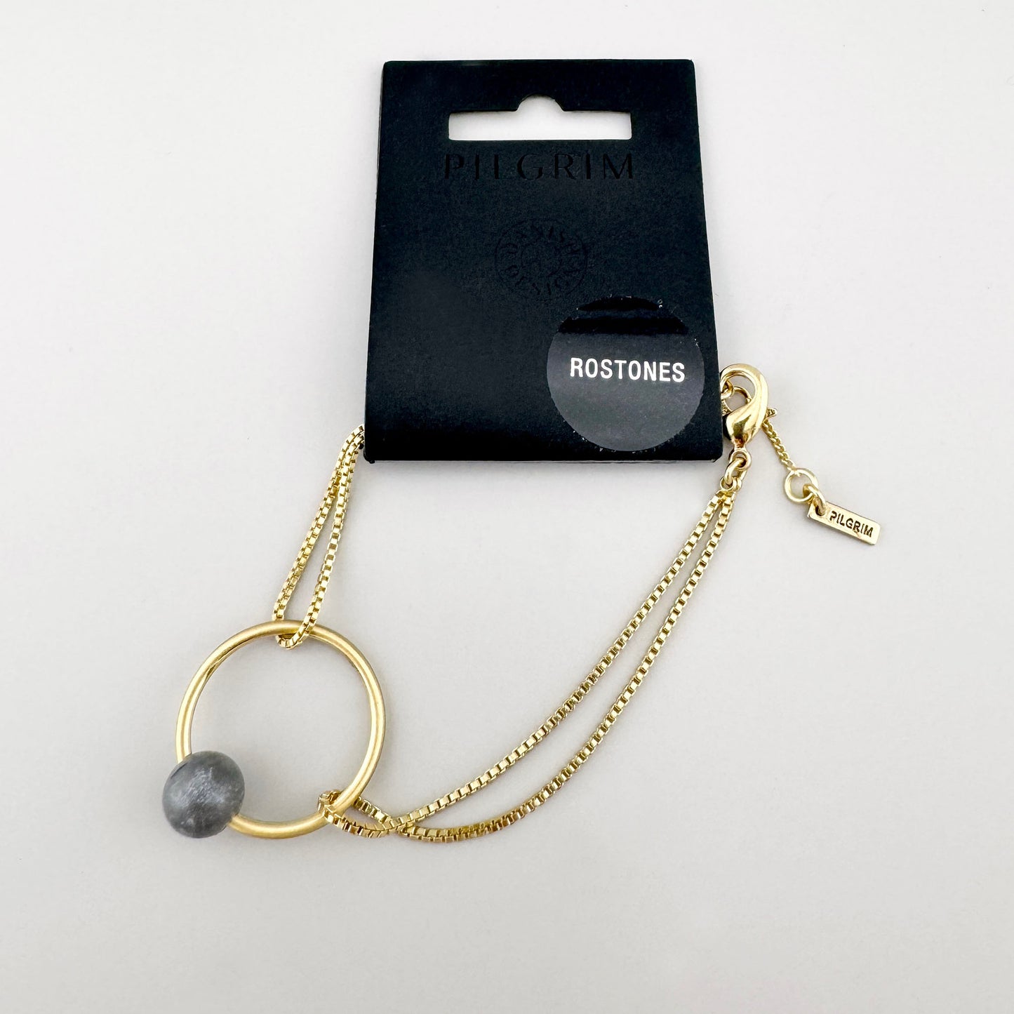 Armband mit grauem Stein und feinem Glanz, präsent in stilvoller Verpackung