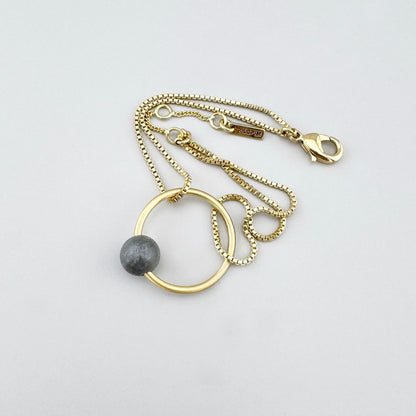 Bransoletka z szarym kamieniem na złotym łańcuszku, spokojny akcent dla codziennego stylu