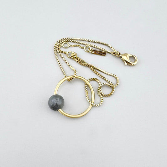 Bransoletka z szarym kamieniem na złotym łańcuszku, spokojny akcent dla codziennego stylu