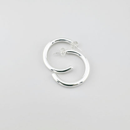 Сережки-півкільця з плакованої сталі, полірована поверхня ловить світло, чистий мінімалізм