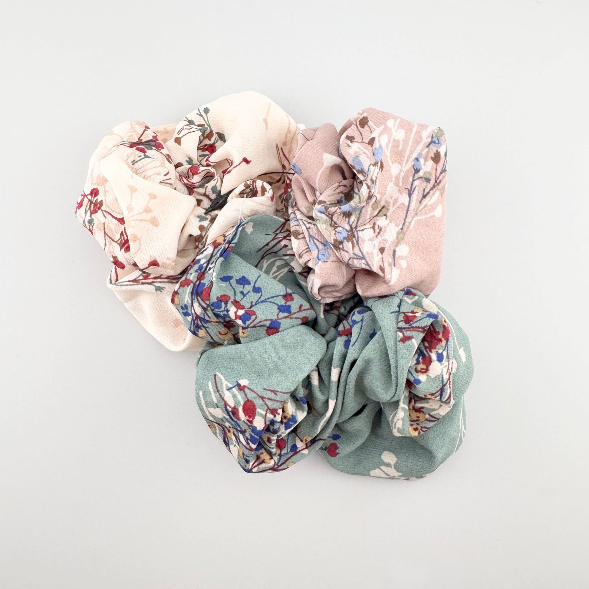 Set de scrunchies IRL con estampados florales en tonos pastel y tejido suave