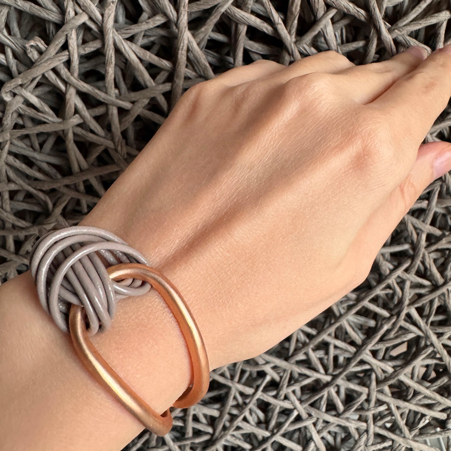 Knot bracelet Sonata worn on the wrist with gray cords and a gold element
