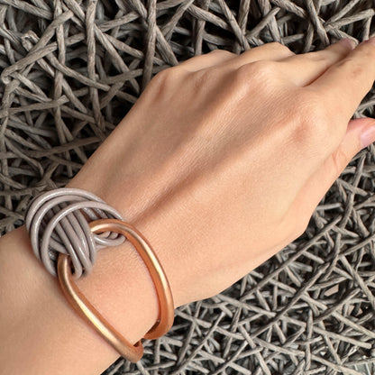 Knot bracelet Sonata worn on the wrist with gray cords and a gold element