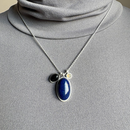 Pilgrim necklace with lapis lazuli, black agate and grey quartz on a silver chain shown on neck