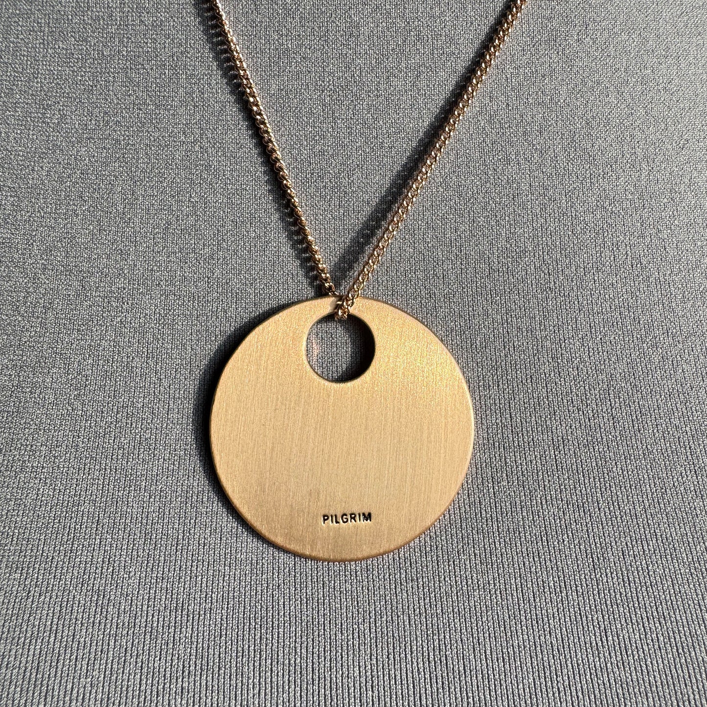 Collier Pilgrim avec grand disque doré mat et zircons subtils comme ciel étoilé