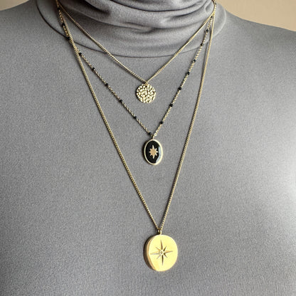 Layered medallion necklace IRL worn on the neck with black beads and gold-tone pendants