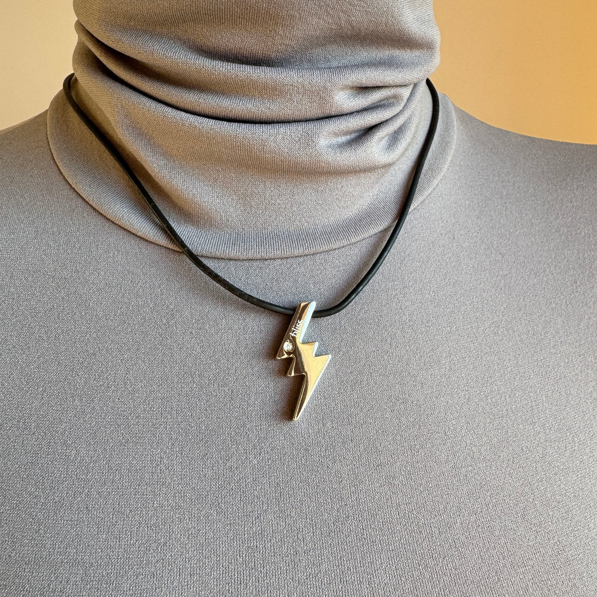 Lightning necklace worn on a black cord with a clean, modern look