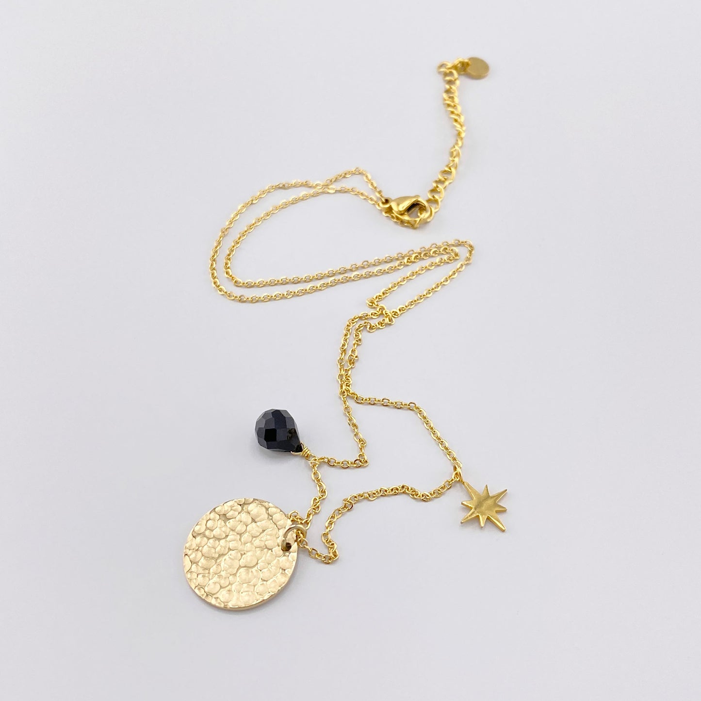 Collar IRL con medallón dorado, estrella y detalle negro sobre cadena fina
