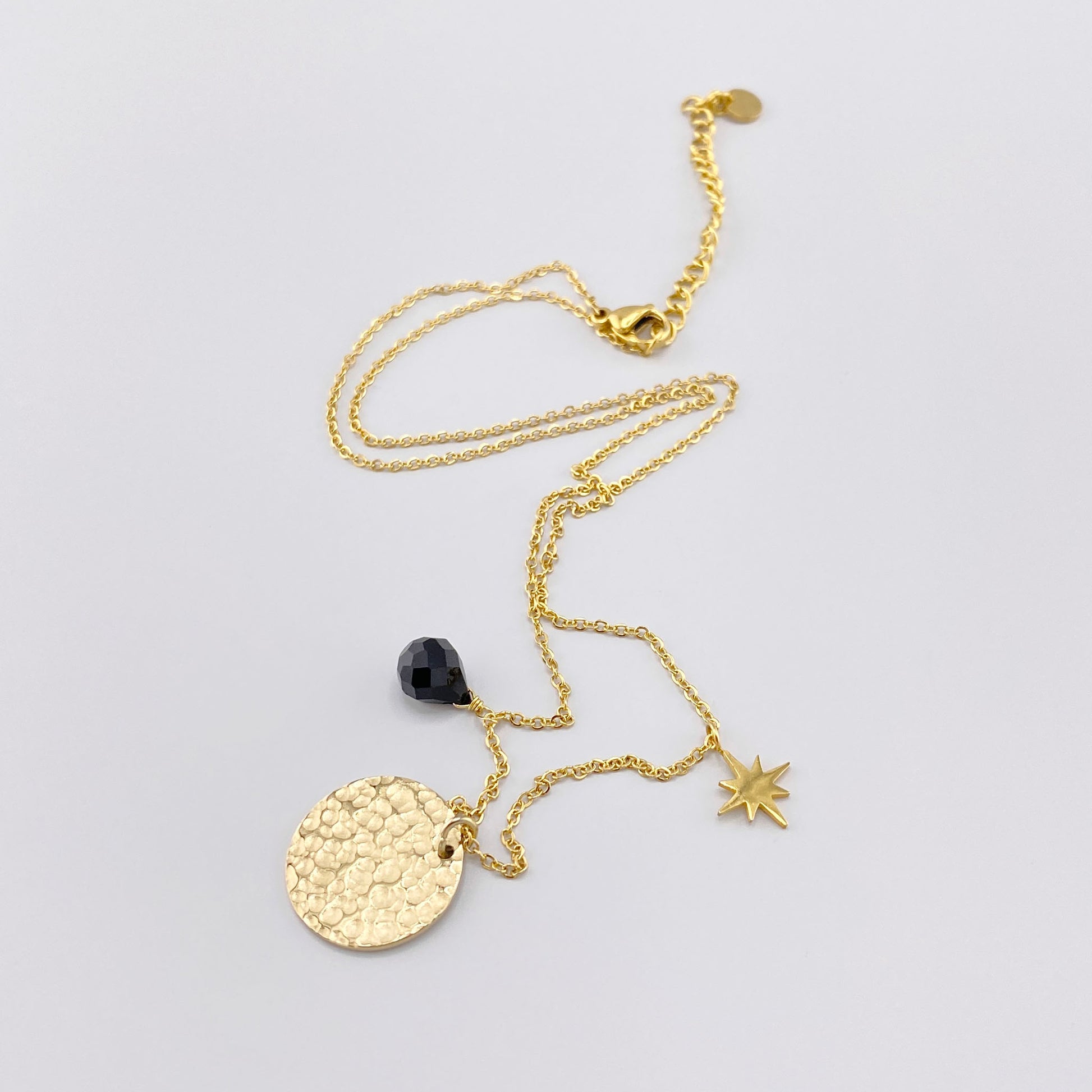 Collar IRL con medallón dorado, estrella y detalle negro sobre cadena fina