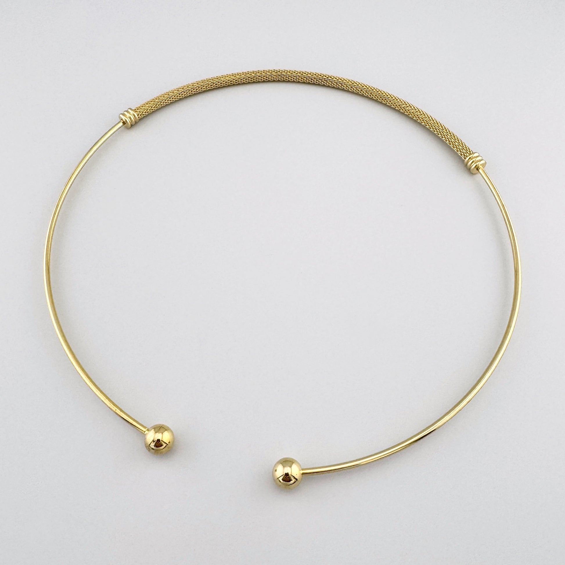 Elegant mesh jewelry set with open collar, cuff bracelet and hoops arranged in clean flatlay