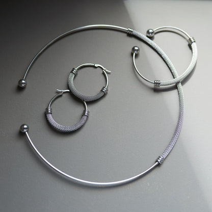 Silbernes Mesh-Set flach arrangiert: Collier, Armspange und Creolen