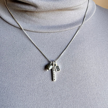 Sleek hematite necklace with delicate charms and adjustable chain