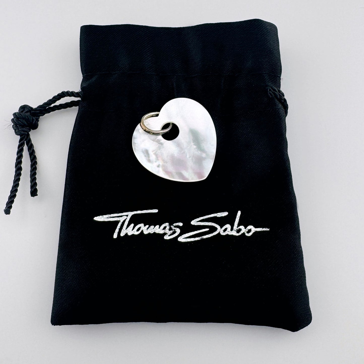 Serce z masy perłowej Thomas Sabo na czarnym firmowym woreczku