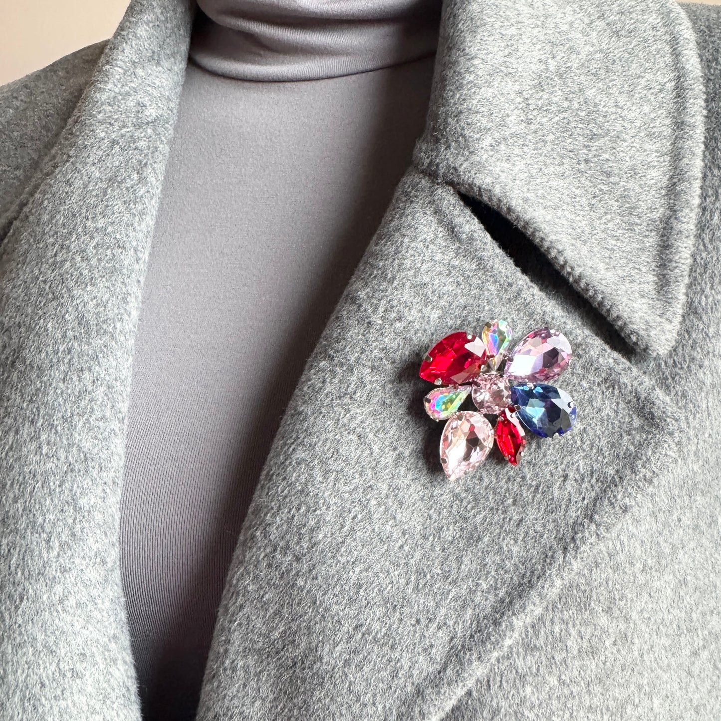 Multicolor crystal flower brooch Sonata worn on a blazer with vivid faceted stones