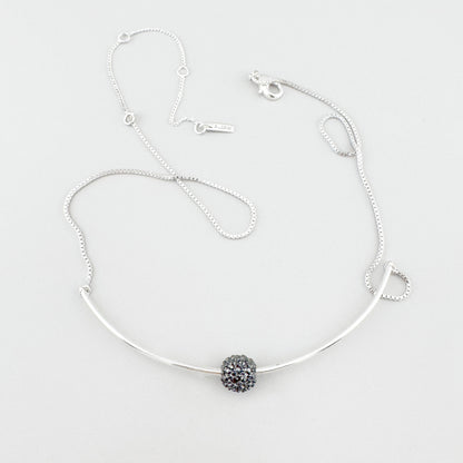 Pilgrim necklace with delicate curve and crystal sphere laid on light background