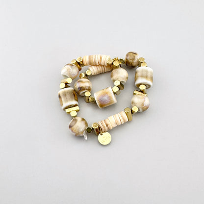 Bracelet en céramique beige avec détails géométriques dorés, style artisanal de la marque Ikita.