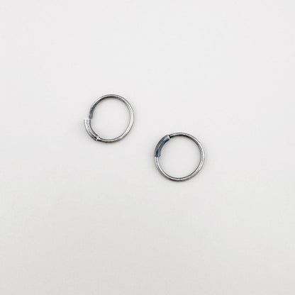 Créoles en argent 925 oxydé, lignes pures et éclat discret, composition à plat élégante