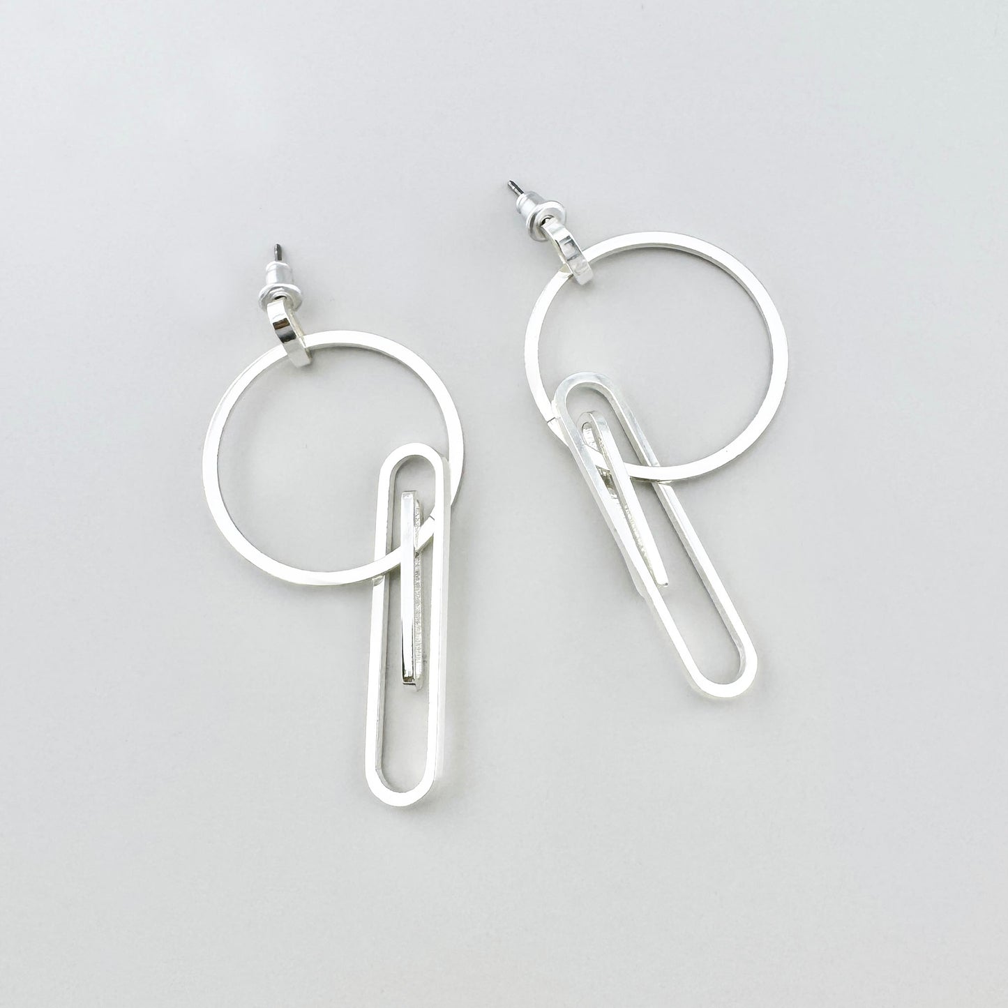 Kolczyki geometryczne Pilgrim z okręgiem i elementem jak spinacz, chłodny połysk