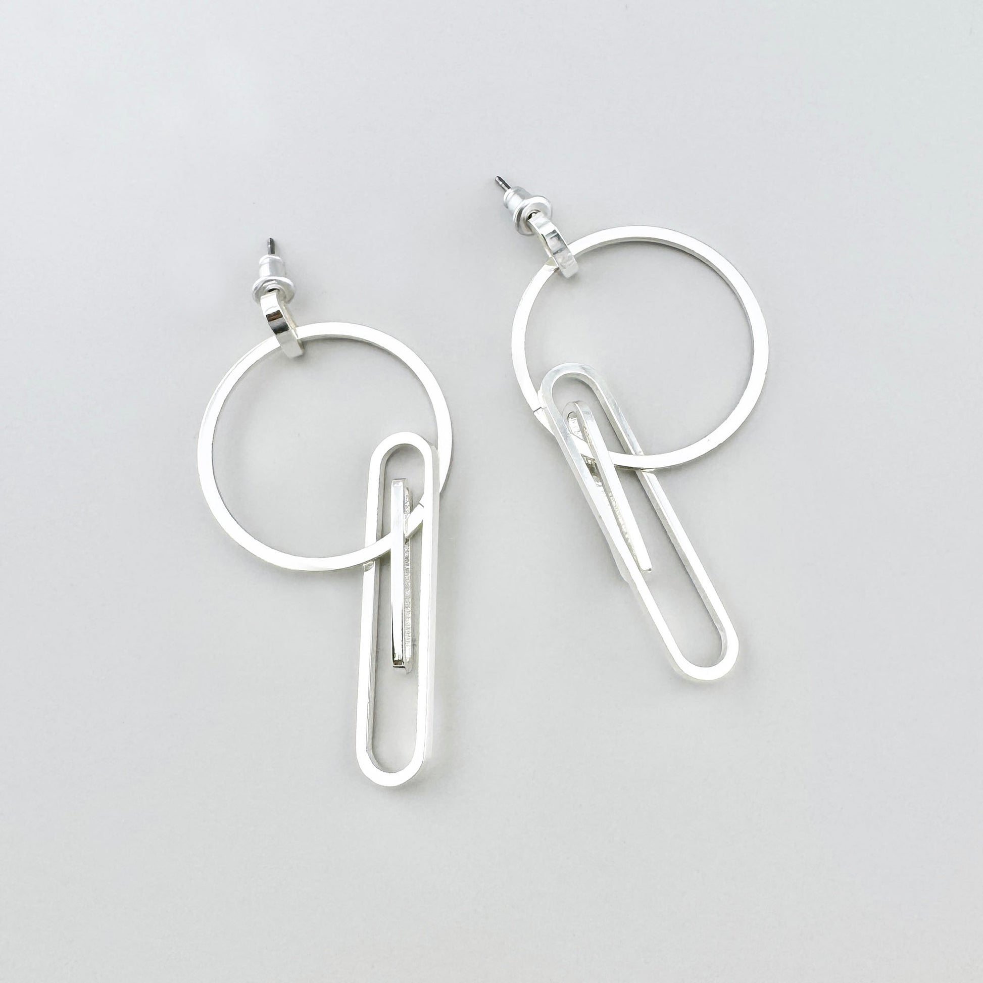 Kolczyki geometryczne Pilgrim z okręgiem i elementem jak spinacz, chłodny połysk